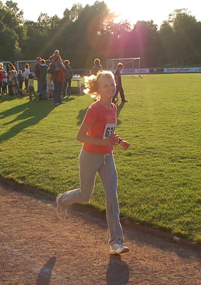 Linda Terwey läuft im Sonnenuntergang ihre fünf Runden zum 2.000m Ziel.